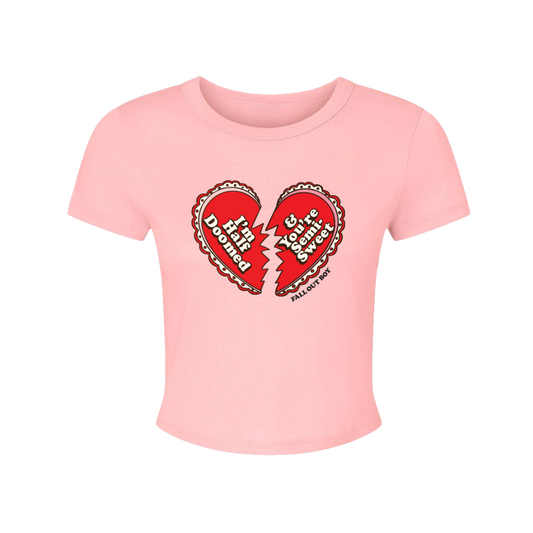 A soft pink cropped t-shirt with a red broken heart graphic and fall out boy text from official fall out boy uk merchandise